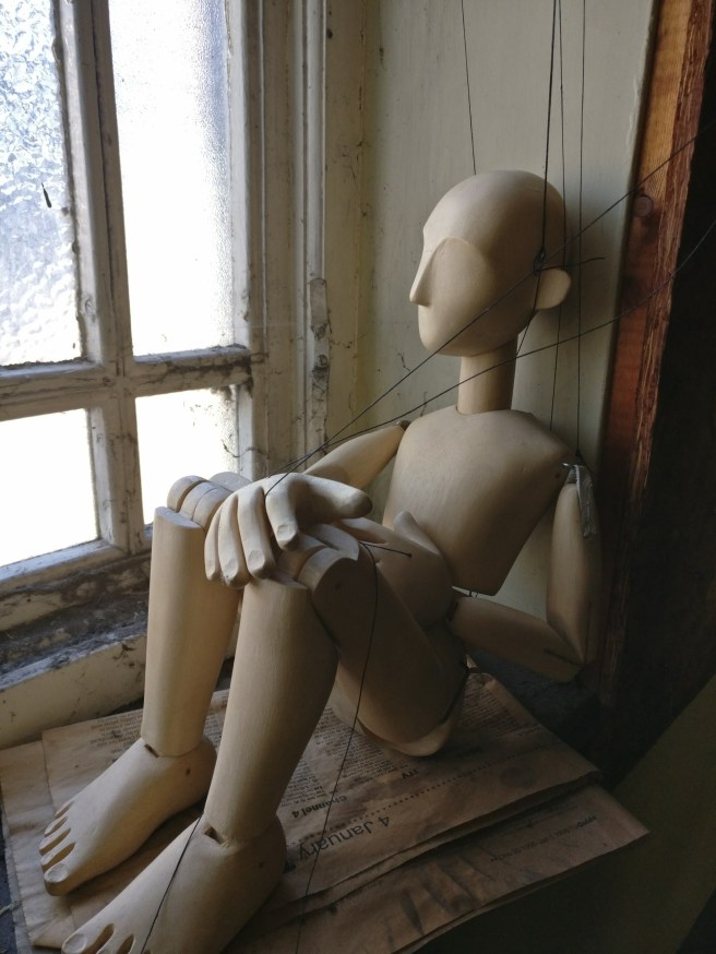 Puppet gazing out of window