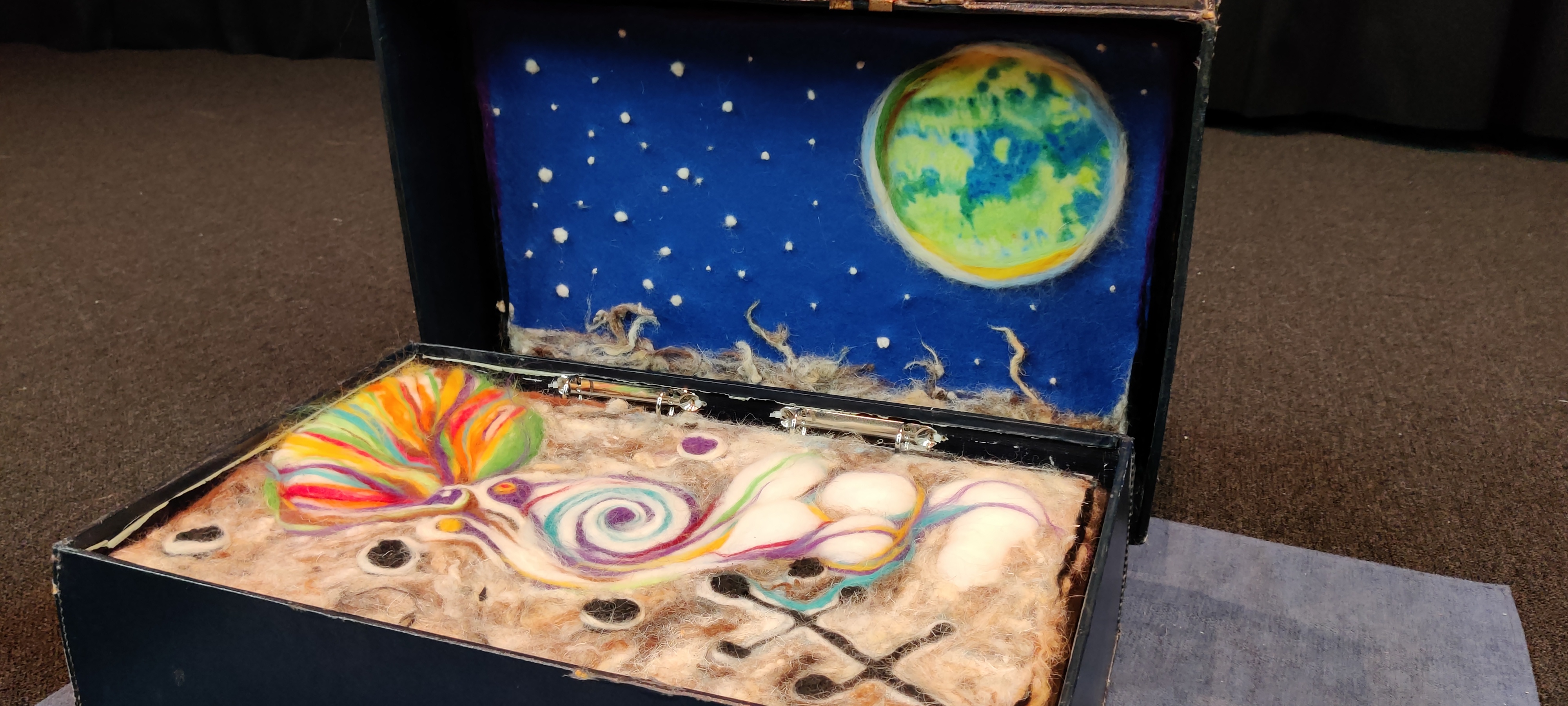 Space...open suitcase showing felted landscape in multi colours