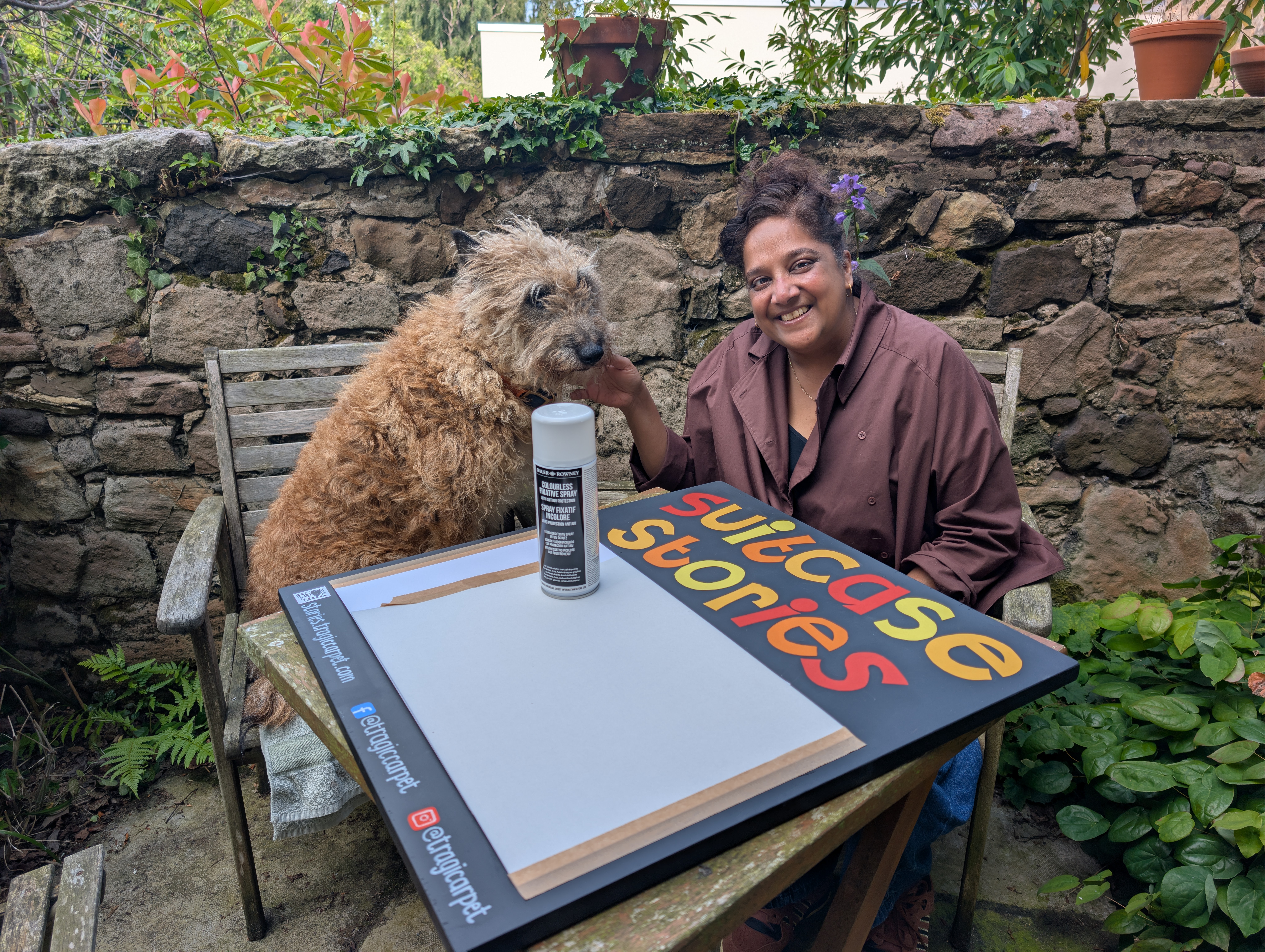picture of woman smiling and sitting with a dog beside the board
