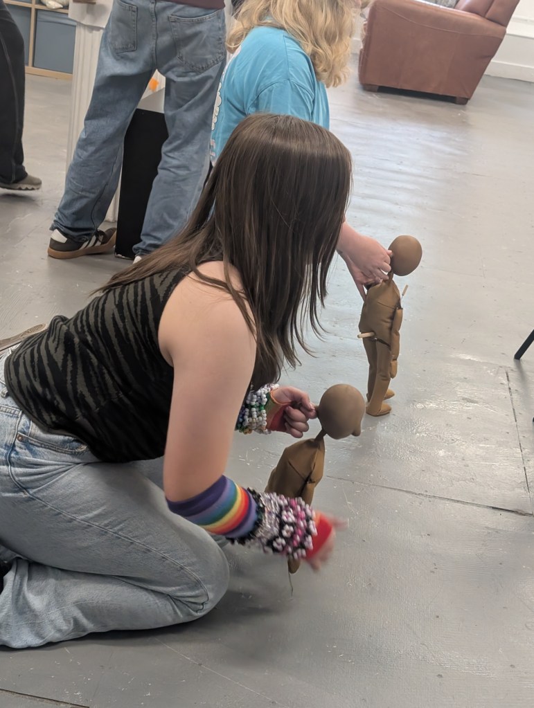 Puppets being manipulated by young people in a workshop setting.