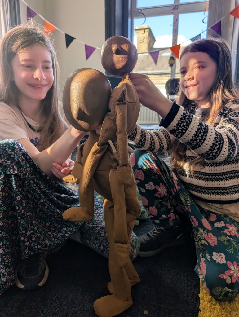 two children exploring how to make puppets work